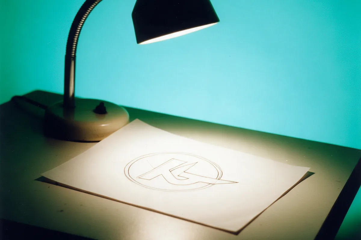 A desk lamp lighting a sketch on paper